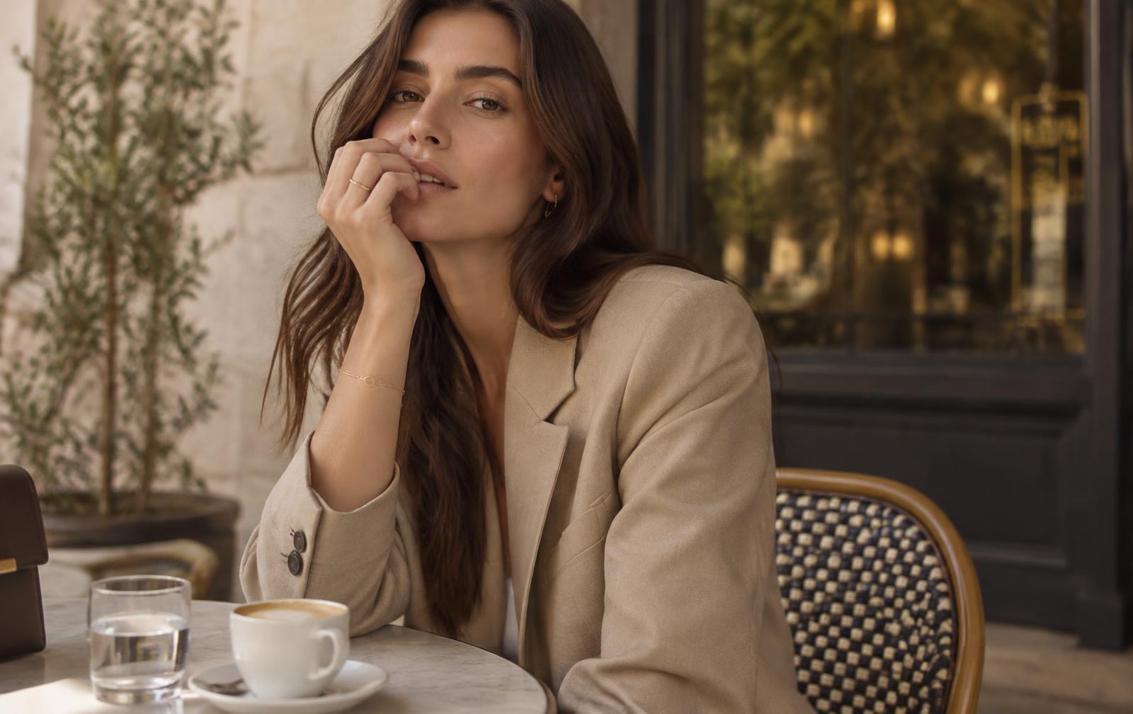 Woman wearing minimal gold jewelry at a cafe